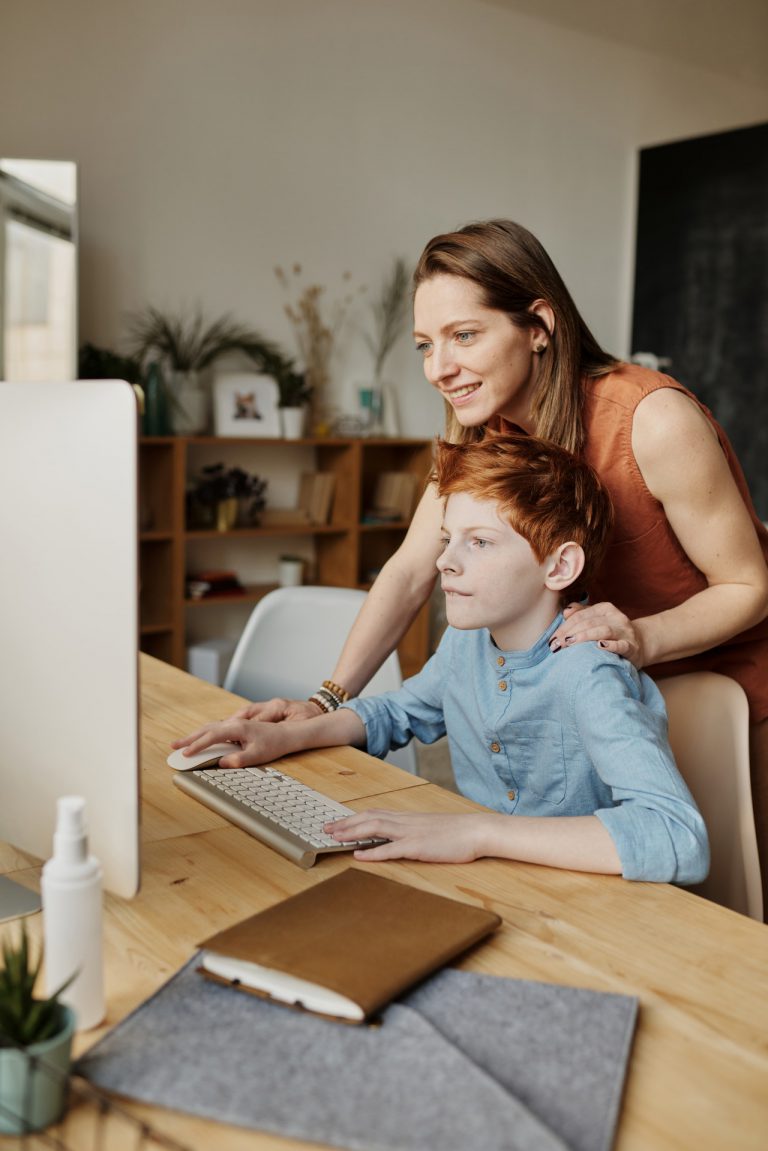 Mother and son home schooling in front of computer